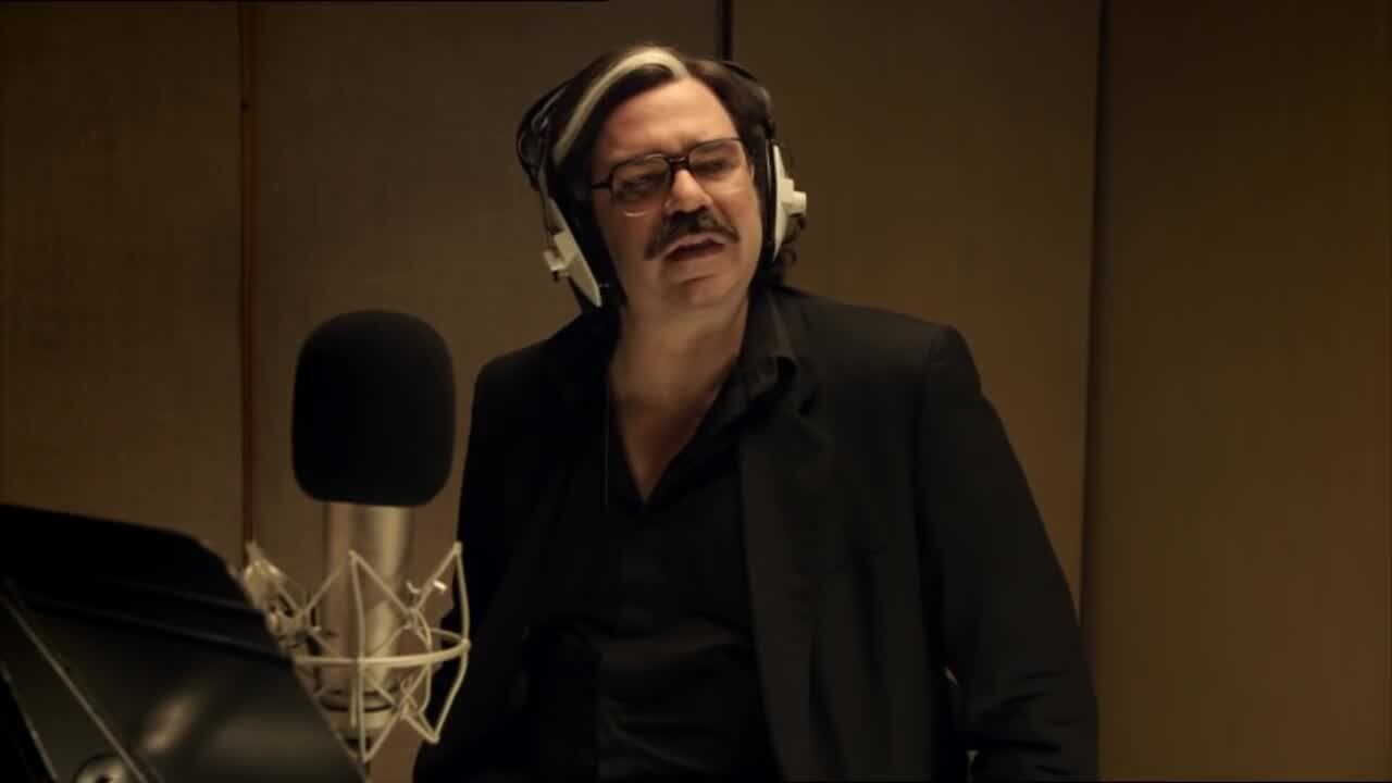 Image shows a still from the TV show, Toast of London, where Steven Toast is in the soundbooth.