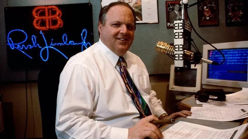 A photo of Rush Limbaugh sat in a radio booth.