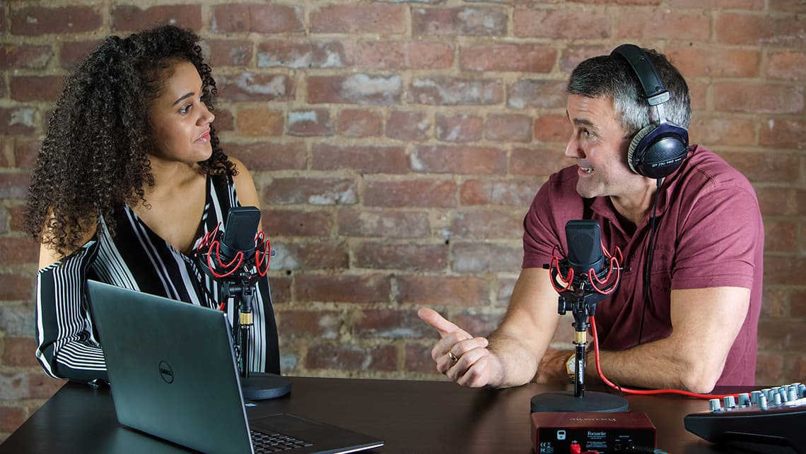 A man and a woman conducting an interview for an online radio station.