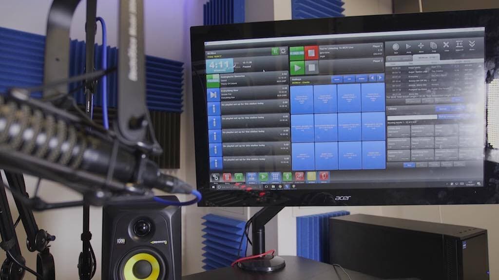 This is a black and blue Acer T232HL Touch Screen Pro Studio Setup image. On the left is a black mixing desk. On the right is the monitor.