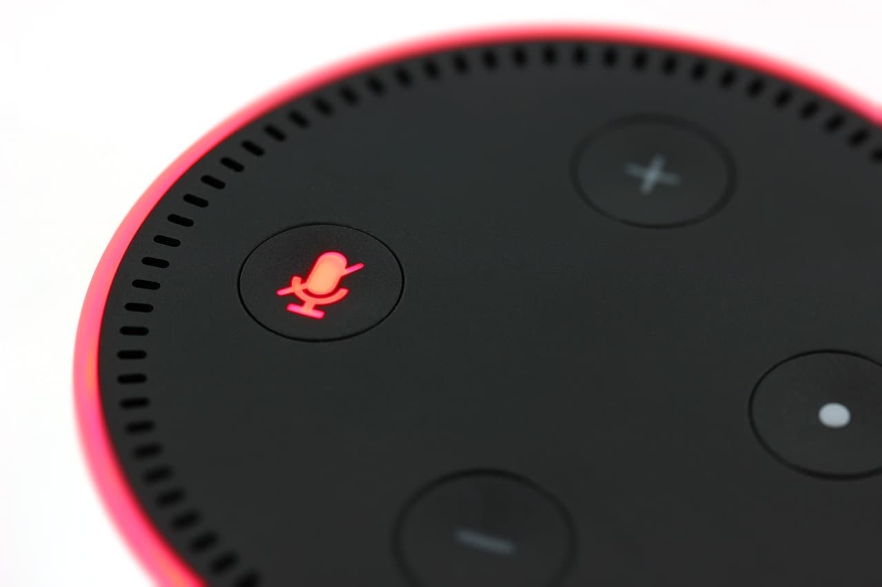 Image is a close up of the top of an Amazon Echo speaker, with the mute button turned on.
