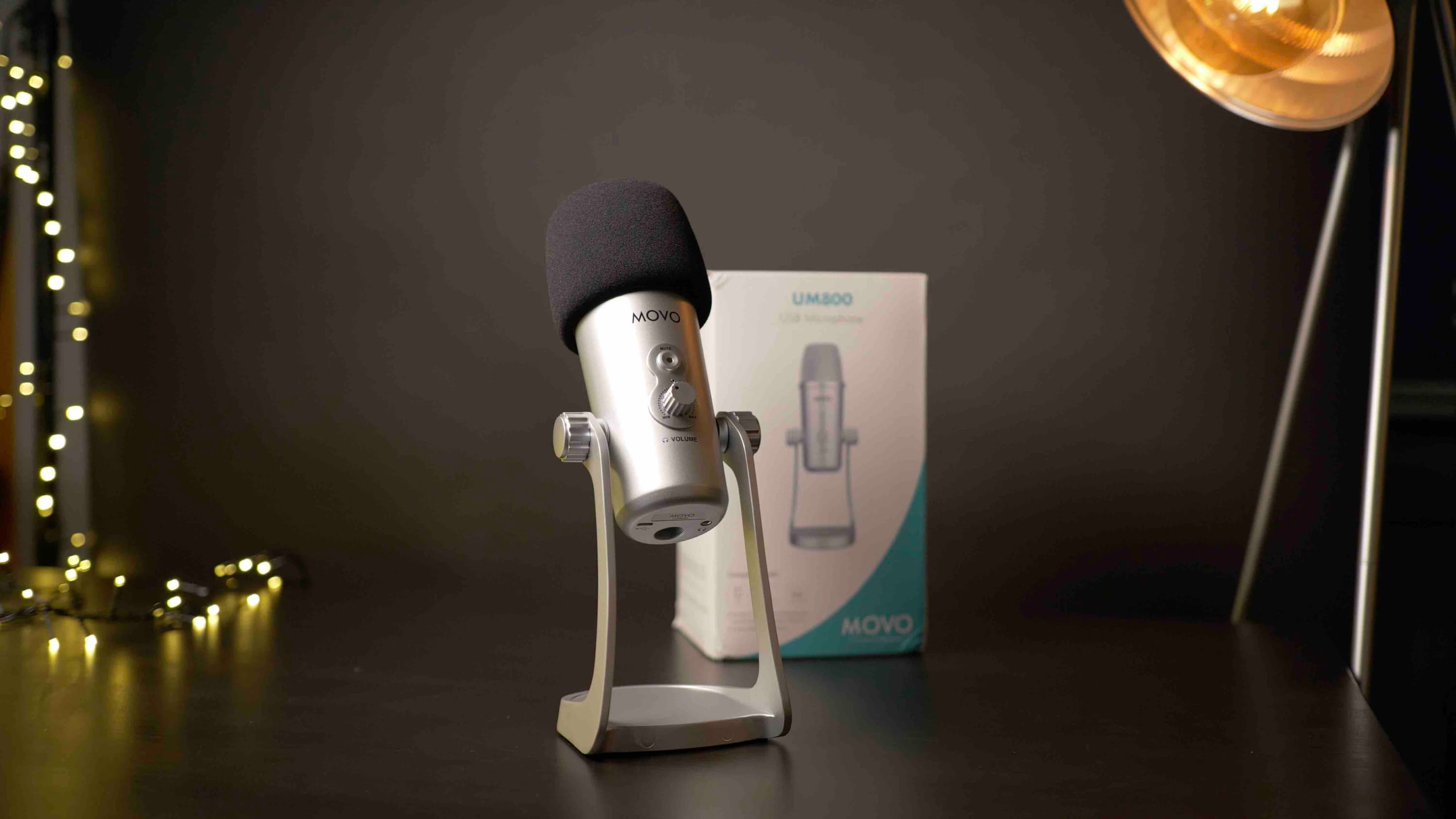Image shows a silver MOVO UM800 microphone, placed on a desk with it's box behind it.