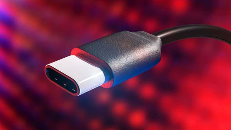 Image shows a close up shot of a USB-C cable against a red background.