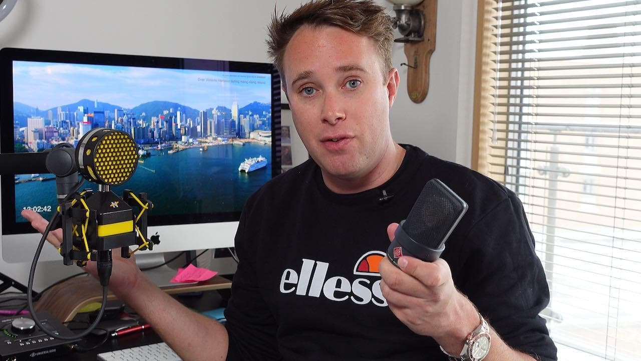 Image shows Radio.co Founder, James Mulvany, holding the NeatMic Worker Bee mic in one hand and the Neumann TLM 103 mic in his other.
