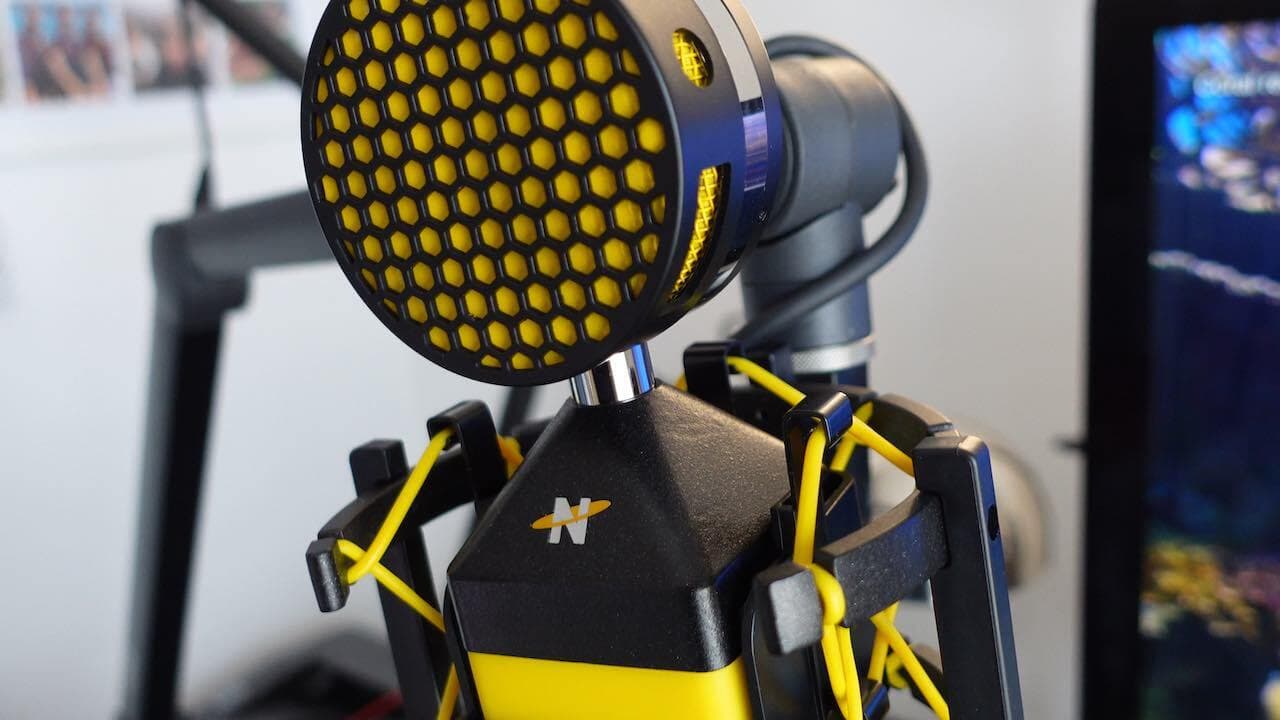 Image shows a close up shot of the NeatMic Worker Bee microphone in a home radio studio.