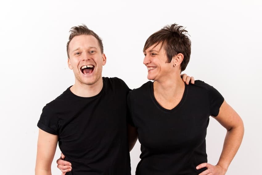 Image shows Chris and Emma from Gaydio, with arms around each other and laughing.