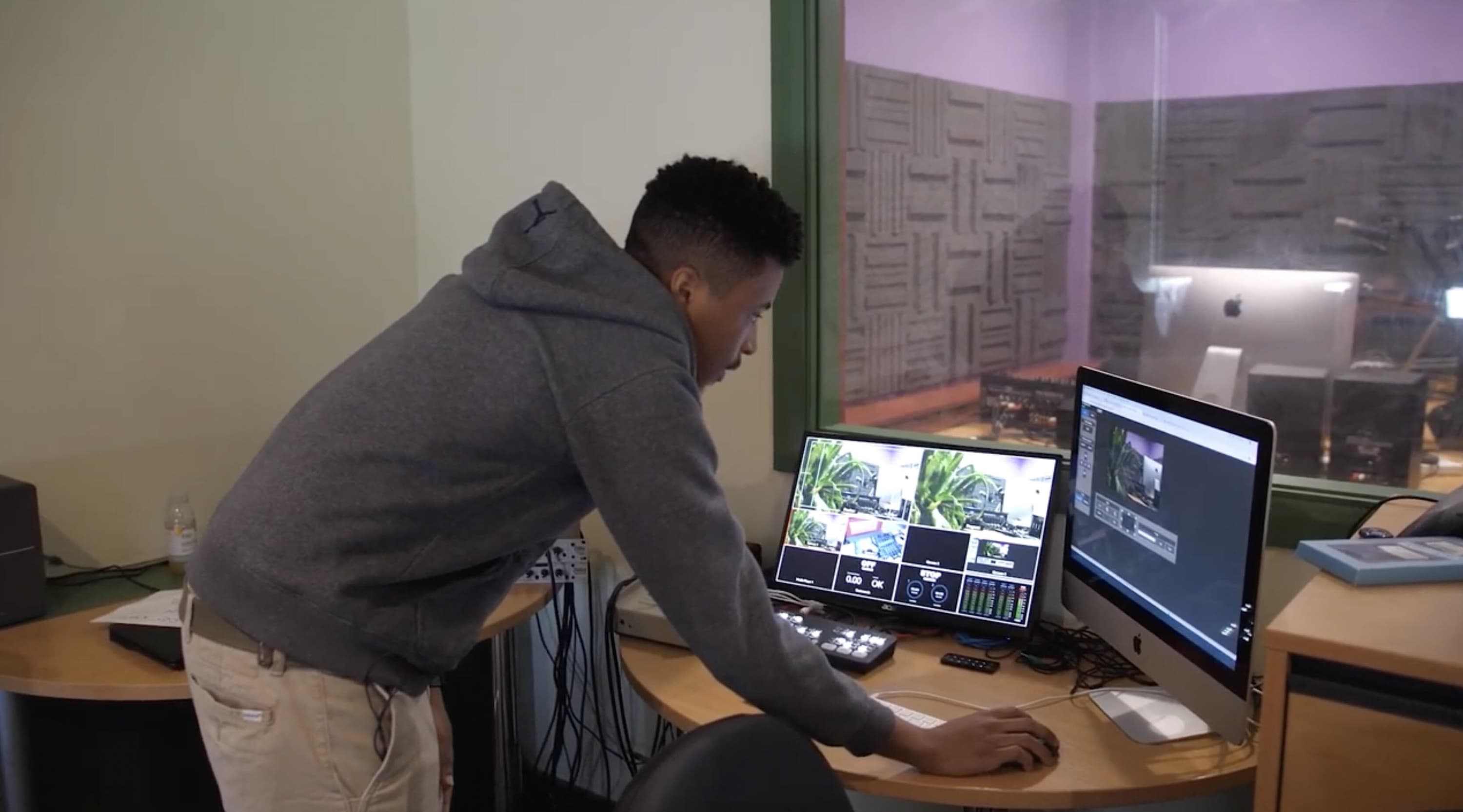 Image shows a man checking the computers in Diversity Radio's studio.