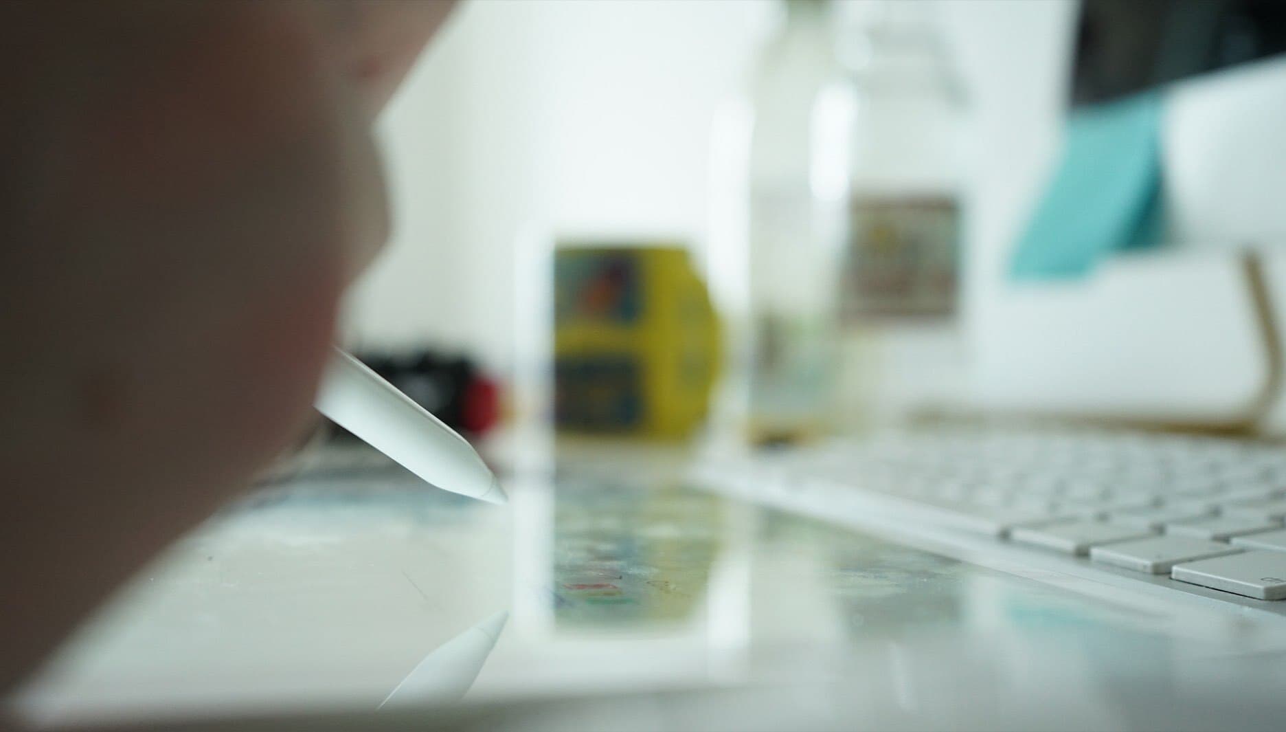 Image shows a close up of a hand using a drawing tablet with a computer.