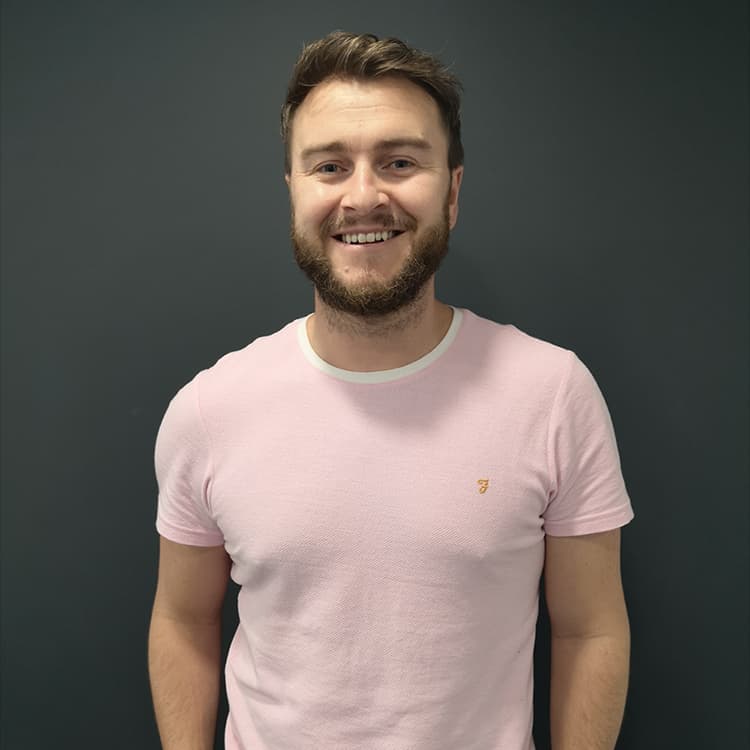Image shows Podcast Radio founder, Gerard Edwards, a white, bearded man in his 20s or 30s and wearing a pink t-shirt.