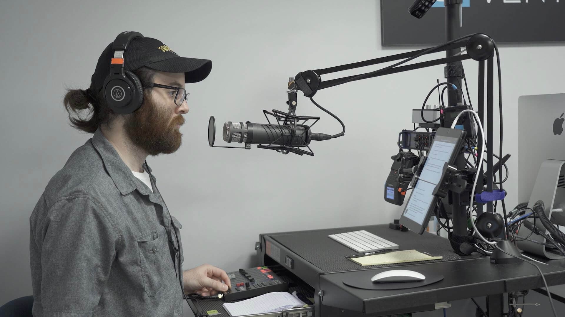 Image shows a man presenting a radio show in the Cybercrime Radio studio space.