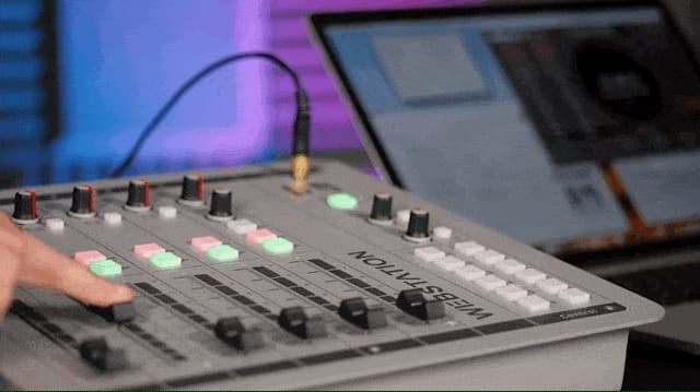 Image shows a hand moving a fader on the D&R WEBSTATION USB mixer.