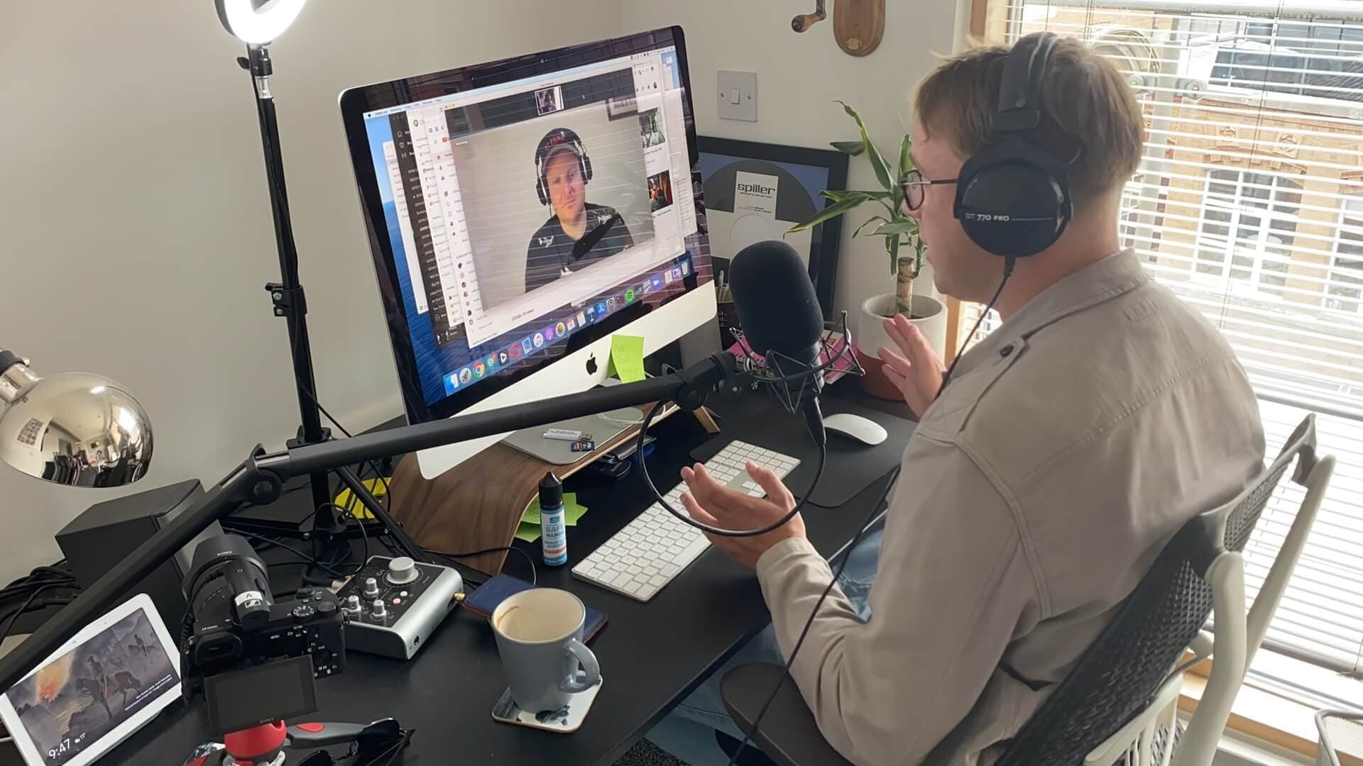 Image shows James Mulvany in his home radio studio talking to a host over a video call.