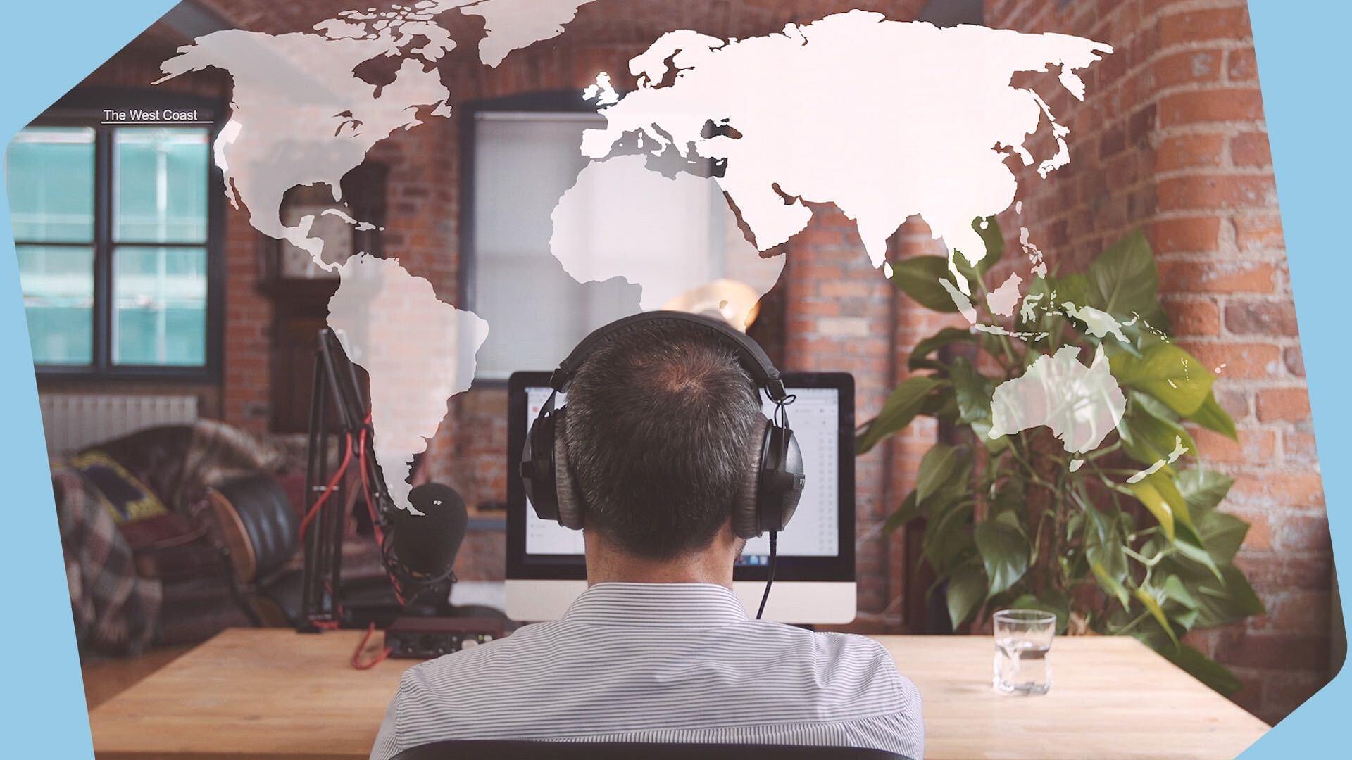 This is an image taken from behind of a man with headphones on looking at a laptop screen. The backdrop is brown with a white overlayed world map above it. The borders of this header image are light blue.