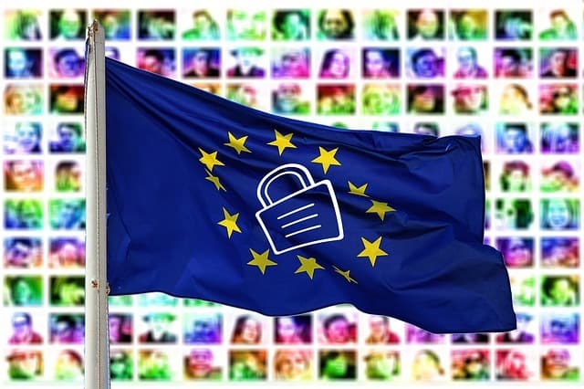 Image is a decorative illustration showing a grid of faces as the background and in the foreground is an EU flag with a padlock in the middle of the stars.