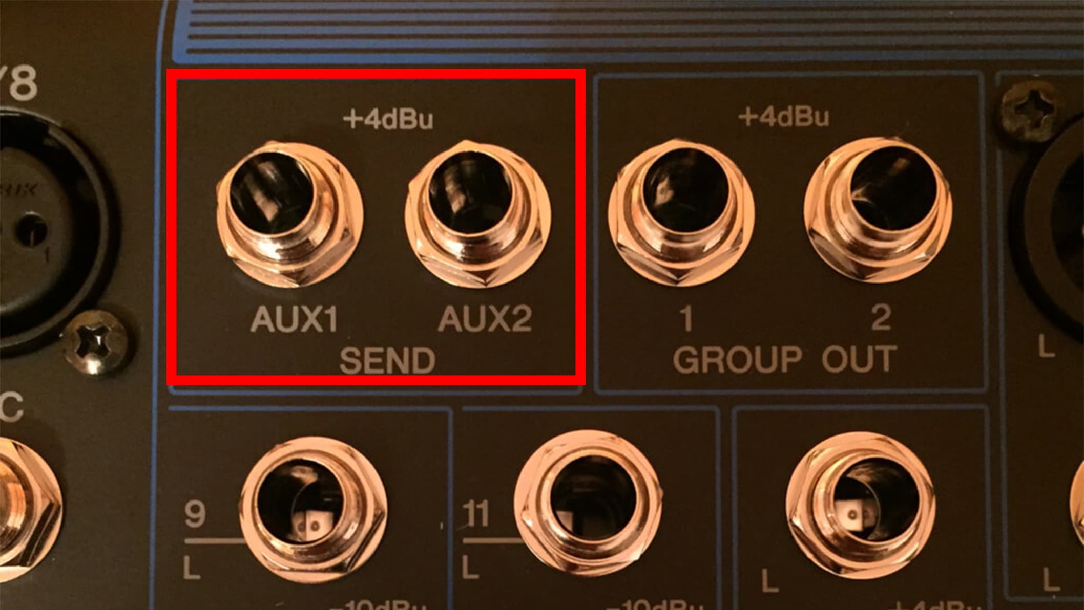 Image shows a close-up of a mixer, showing the Aux input and Aux outputs highlighted by a red box.