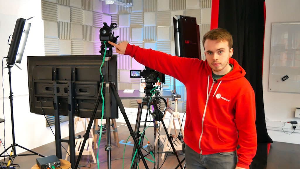 Image shows a man pointing to the HDMI outputs on the video cameras being used in a livestream.