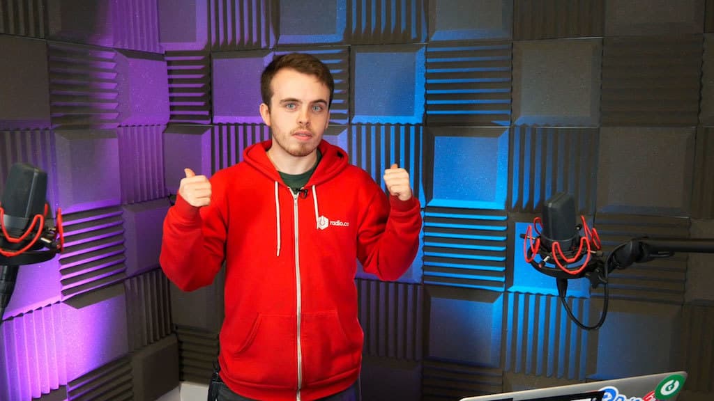 Image shows a man standing in a soundproofed radio studio.