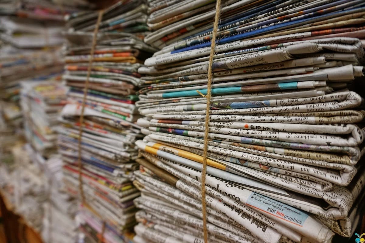 Image shows several bundles of newspapers tied together.