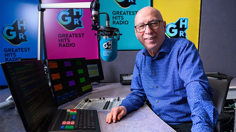Image shows the radio presenter, Ken Bruce, posing in the Greatest Hits Radio studio.