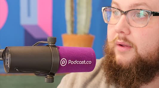 Image shows a man talking into a Podcast.co branded microphone.