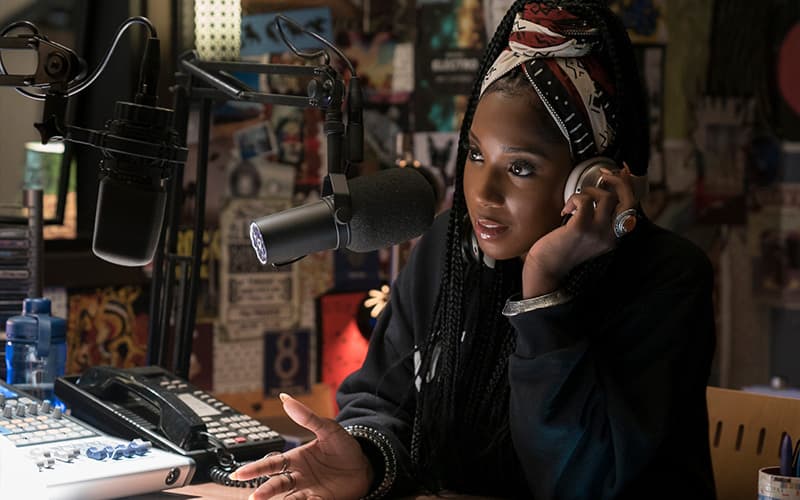 Image shows the character Joelle Brooks presenting her radio show in Dear White People.