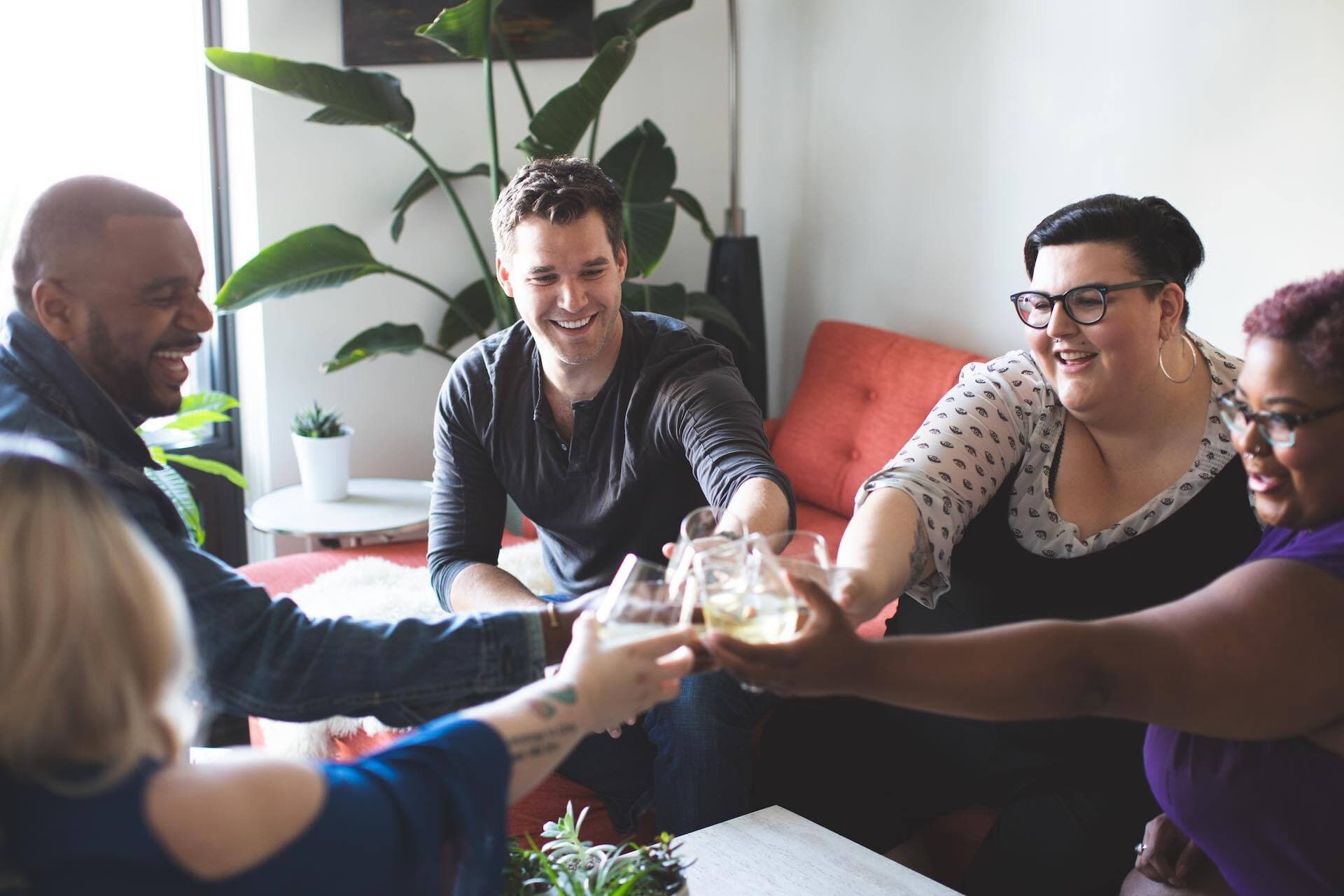 Image shows a group of friends toasting with drinks.