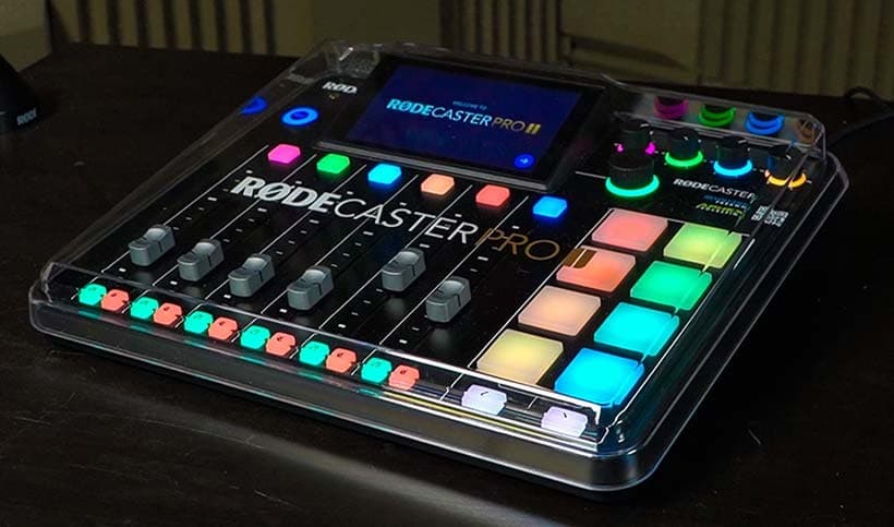 Image shows a RODECaster PRO II interface, turned on and lit up, on a desk.