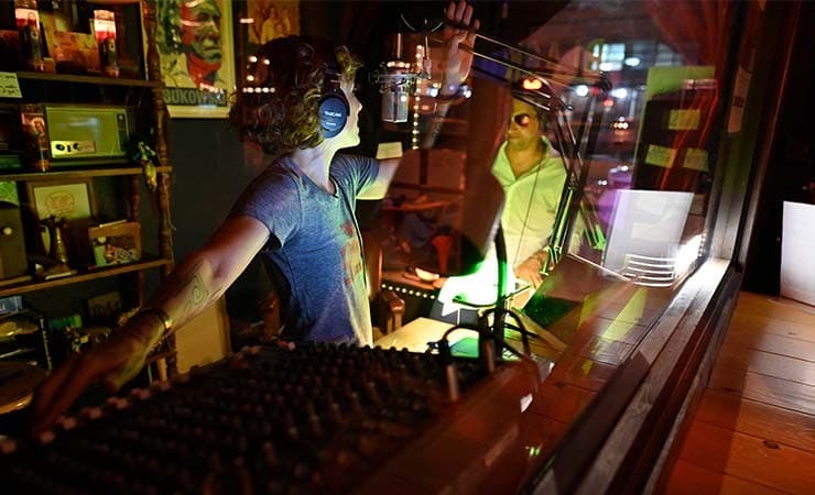 Image shows a presenter from Black Sparrow Radio in the radio booth.