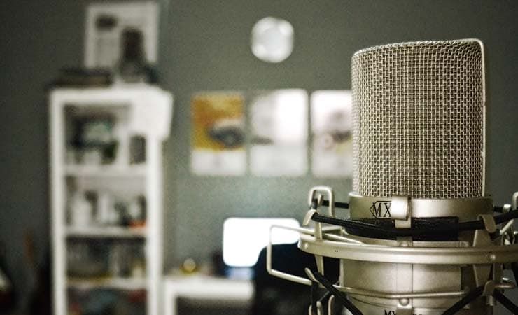 Image shows a close up of a silver radio microphone in a studio.