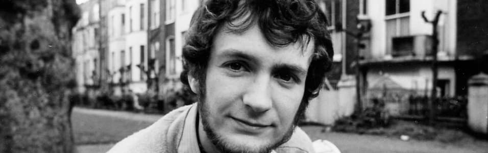 Image shows a black and white photo of a young Kenny Everett on a street.