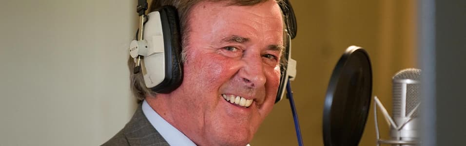 Image shows a smiling Terry Wogan in a radio booth.