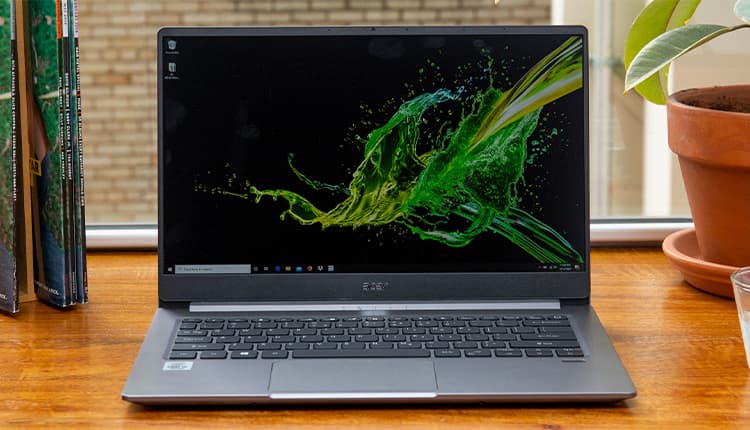 Image shows the Acer Swift 3 Laptop, open on a wooden desk.