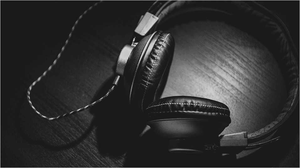 This is a black image of headphones with a wire inputted in the centre.