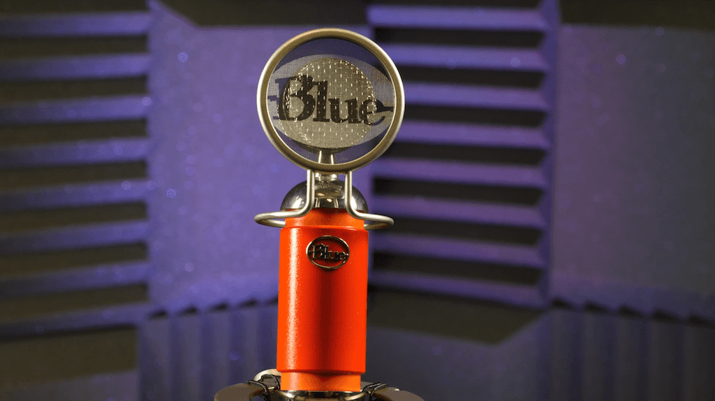 Image shows the Blue Spark microphone spotlighted in a soundproofed studio.