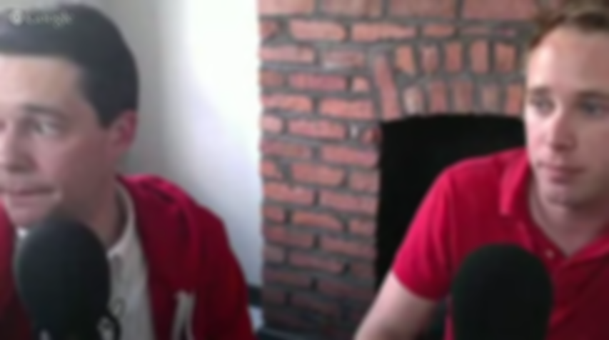 This is a Blurry Image of the same two white men in the cover image for this article. They both wear red clothes. The backdrop is a redbrick fireplace.
