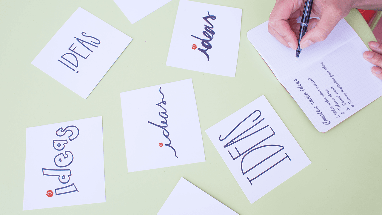 Image shows a table with cards saying "ideas" strewn all over it.