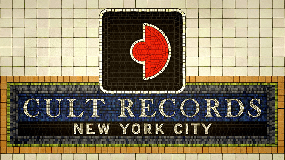 This is an image of the Cult Records logo against a tiled wall. It is a black square with a red insert in the middle, looking like a record in a sleeve.