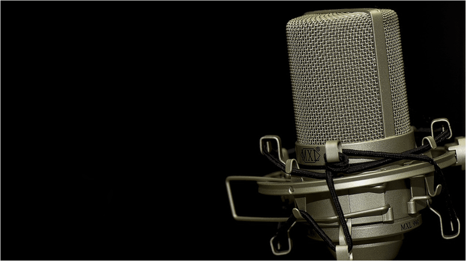 This is a silver mic on a silver stand in the right hand corner of the image. The backdrop is plain and black.