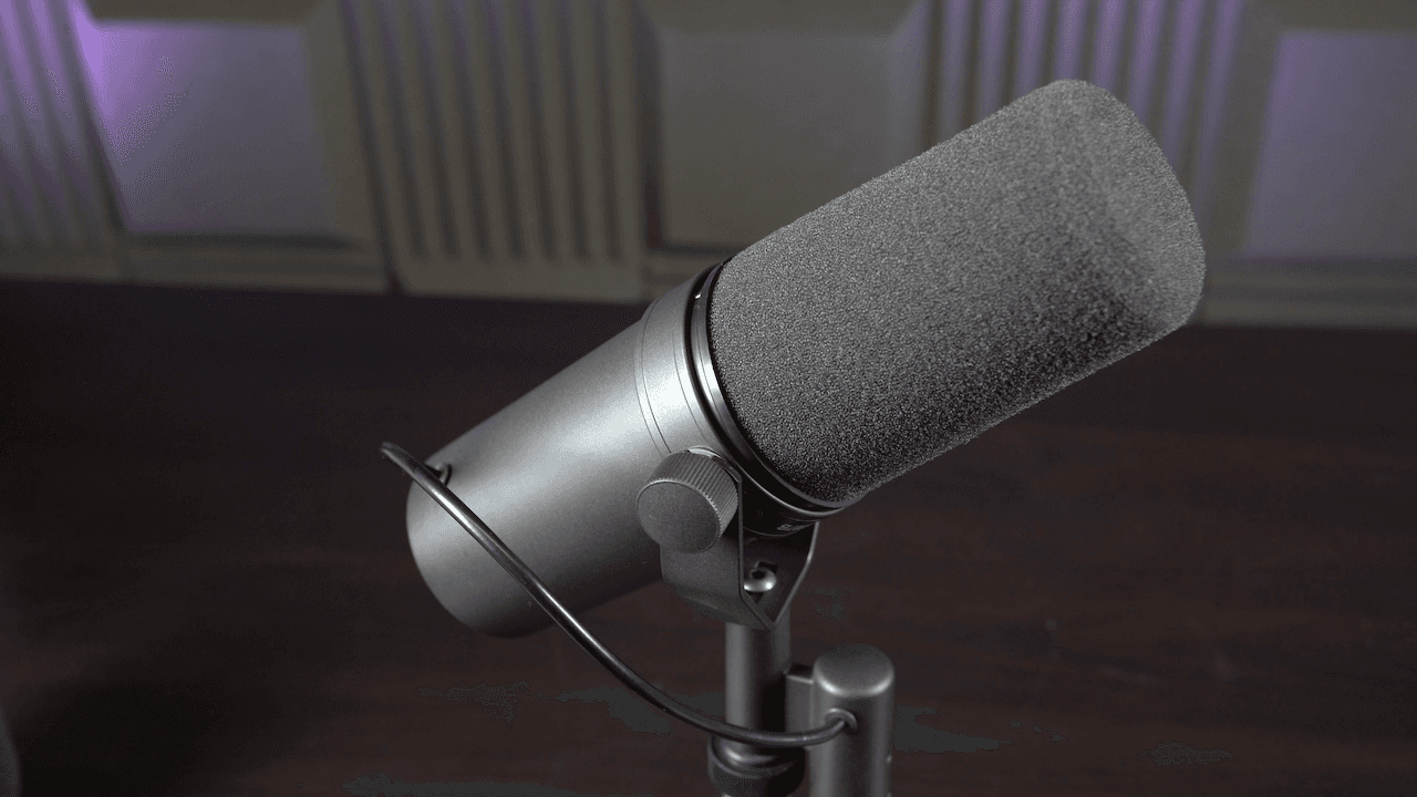 Image shows a Shure SM7B microphone on a desk stand.