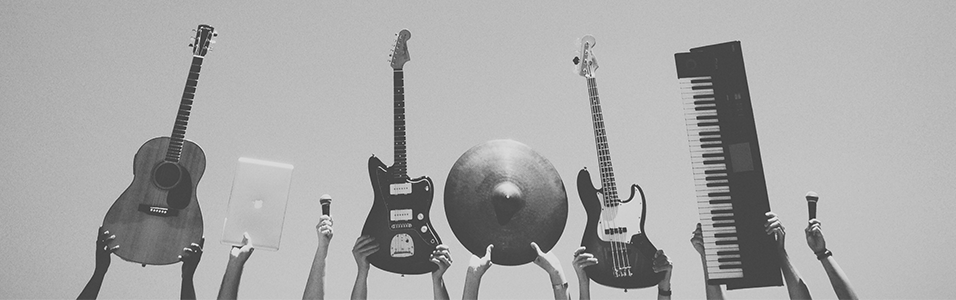 This is a grey background with 6 instruments in the centre being held up by hands. There are three guitars, a cymbal, a keyboard and a Macbook.