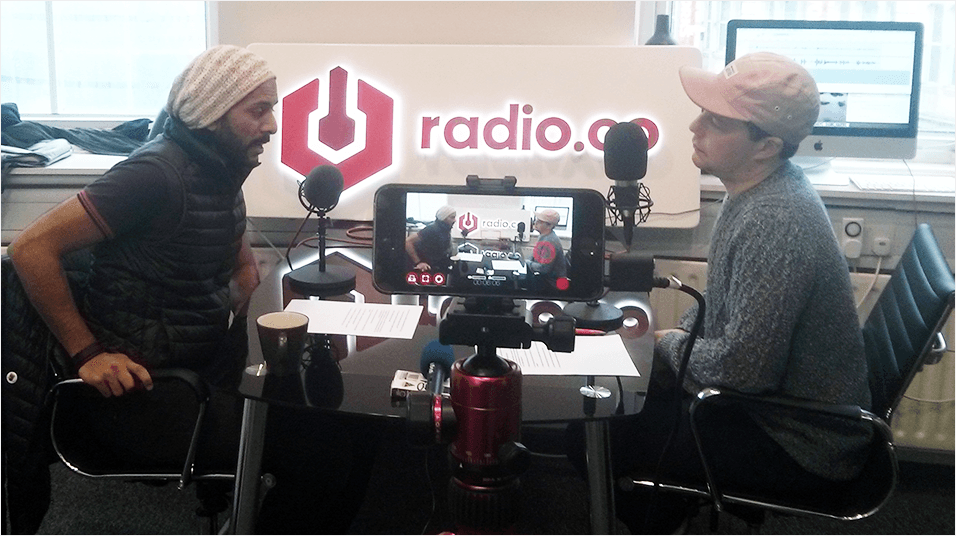 Image shows two men conducting an interview, with it being filmed on to a smartphone.