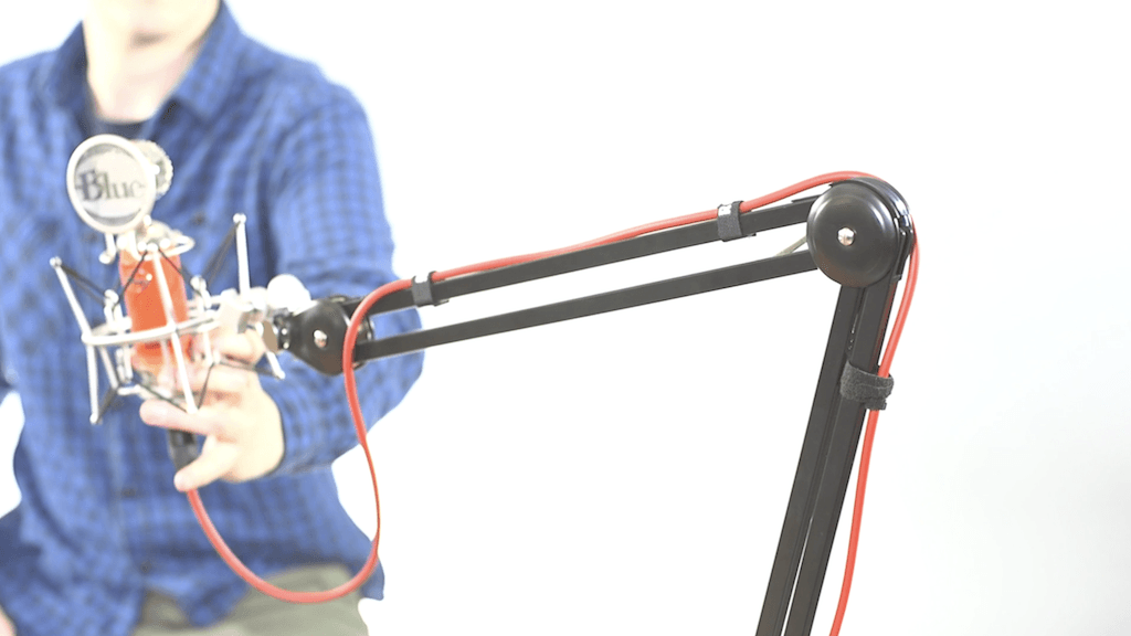 Image shows a man adjusting a boom arm