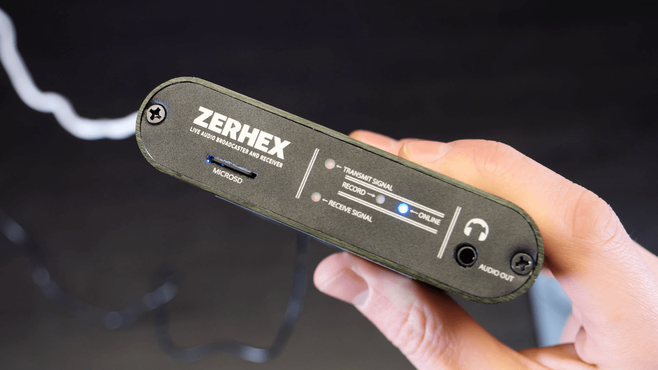 Image shows a hand holding a Zerhex Bridge, with the back of the device held up to the camera.